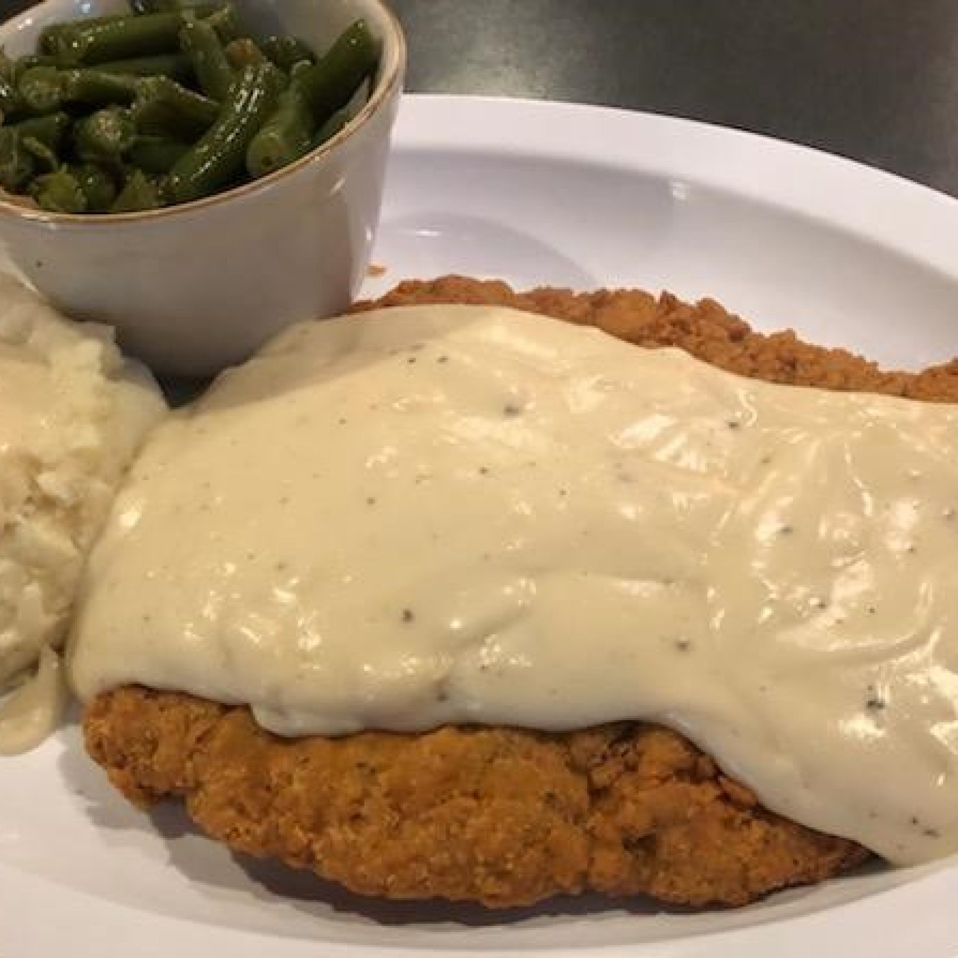 Oscar's Smothered Breaded Pork Tenderloin w mashed potatoes, gravy and green beans - widescreen